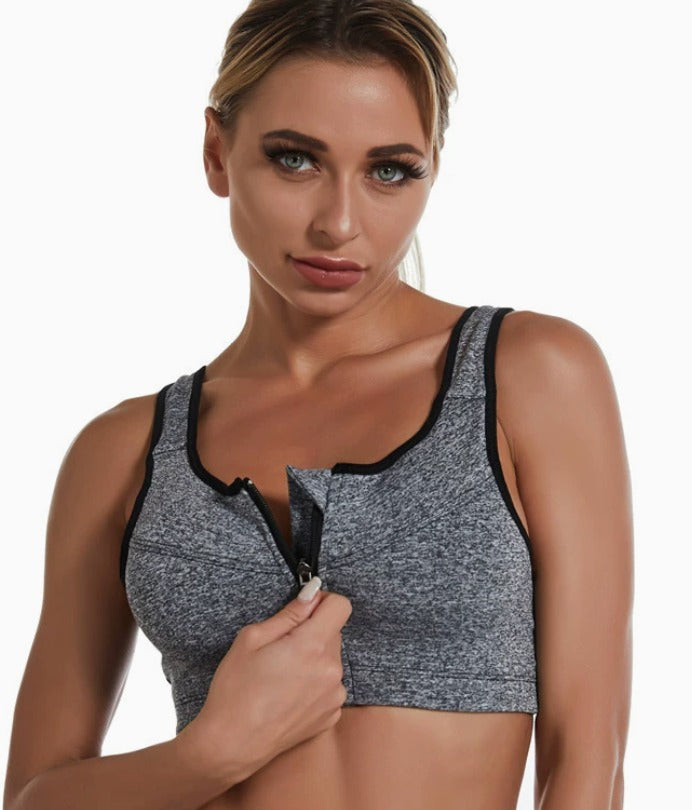Woman unzipping the heather gray Bloom Zip Bra sports bra